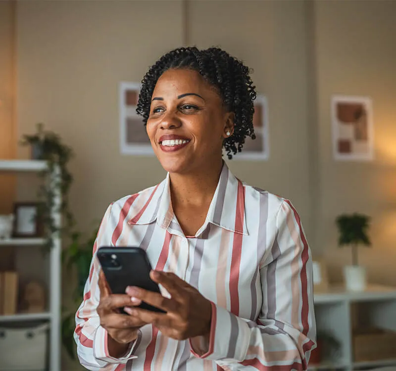 Woman smiling with smartphone representing virtual care